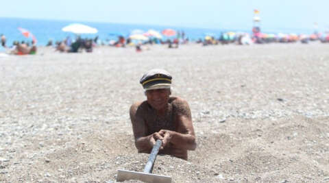 Yaşlı adam 40 dereceyi bulan sıcaklıkta sahilde kendini kuma gömüp şifa aradı