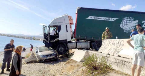 Lastiği patlayan tır önünde sürüklediği otomobil ile sahile uçtu