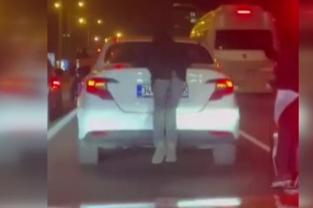 Otomobilin arkasına tutundu, hem kendini hem trafiği tehlikeye attı