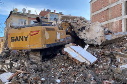 Ağır hasarlı binanın enkazı iş makinesinin üstüne yıkıldı