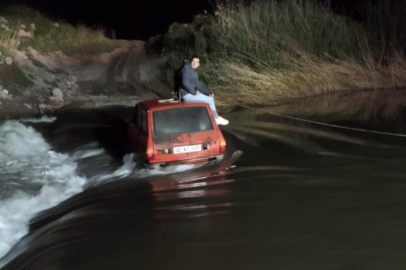 Akıntıya kapılan otomobildeki iki kişi iş makinesiyle kurtarıldı