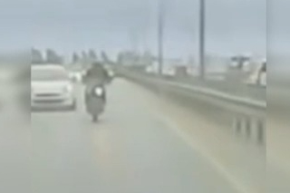 Köprüden sarkan reklam afişi motosikletliyi savurdu