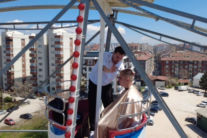 Dönme dolabın zirvesinde macera dolu saç kesimi
