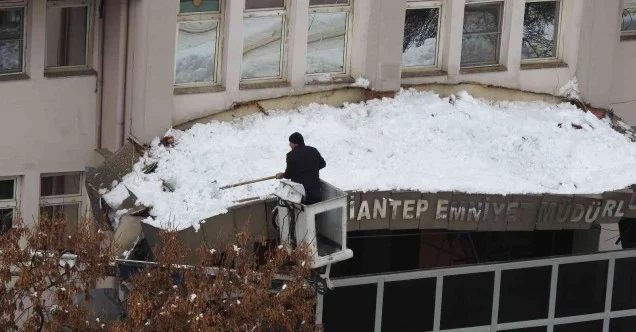 Emniyet müdürlüğünün kapı girişi çatısına düşen kar kütleleri vinç yardımıyla temizleniyor